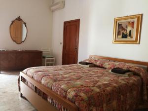 a bedroom with a bed and a mirror on the wall at La Ozza B&B in Otranto