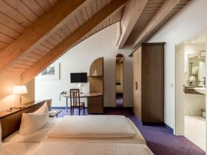 a bedroom with a large bed and a desk at Andante Hotel Dresden in Dresden +51 photos