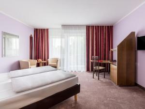 um quarto de hotel com duas camas e uma secretária em Andante Hotel Dresden em Dresden