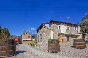a stone house with barrels in front of it at Agripodere Il Falco in Pontremoli