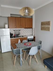 a kitchen and dining room with a table and chairs at ΔΙΑΜΕΡΙΣΜΑ ΣΤΟ ΛΙΤΟΧΩΡΟ ΜΕ ΕΚΠΛΗΚΤΙΚΗ ΘΕΑ in Litochoro