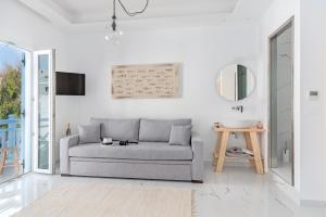 a white living room with a couch and a mirror at Central Suites Mykonos in Mýkonos City