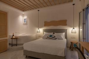 a bedroom with a bed and a bath tub at Central Suites Mykonos in Mýkonos City
