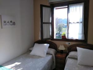 リバデセリャにあるLa Quintana de Ribadesellaのベッドルーム1室(ベッド2台、窓付)