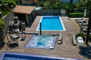a swimming pool in a backyard with a wooden deck at Apartments Petra Krk in Krk