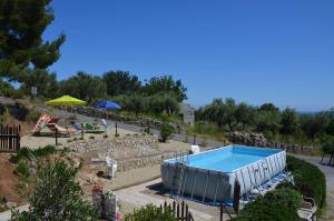 a swimming pool in a yard with a rock garden at Agriturismo Tendapiccola in Ceriale