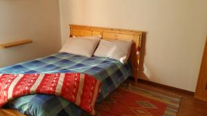 1 dormitorio con 1 cama con una manta colorida en I Tre Ciliegi Apartment, en SantʼOmobono Imagna