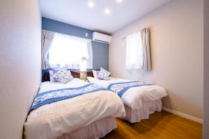 two beds in a room with two windows at villa hanasaku 富士河口湖町A棟 in Fujikawaguchiko