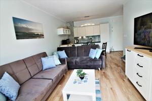 a living room with a couch and a table at Closer to the Sea Apartments in Kołobrzeg