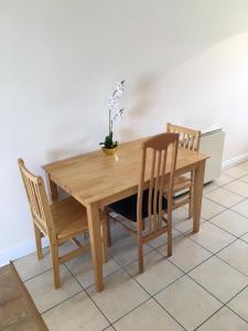 una mesa de madera con 2 sillas y un jarrón. en Glen Abhainn Standard Budget Accommodation, en Athlone