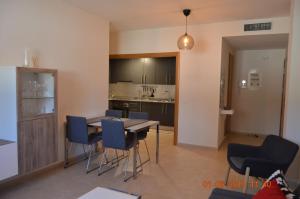 Una cocina y un comedor con mesa y sillas. en APARTAMENTO PISCINA VIENA, en Roses