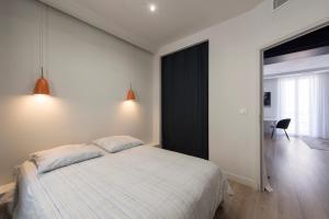 a bedroom with a bed and a black accent wall at Nouveau F2 calme cœur de ville 1min de la plage in Saint-Raphaël