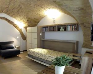 een slaapkamer met een bed, een bank en een stoel bij Monolocale quartiere medievale in Ortona