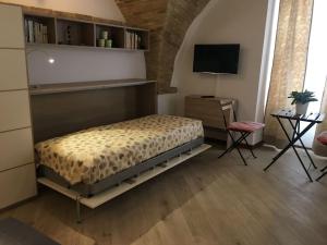 een slaapkamer met een bed en een televisie en een tafel bij Monolocale quartiere medievale in Ortona