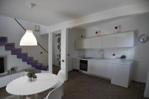 een keuken met witte kasten en een witte tafel bij CASAILCAMBIO in San Marziale
