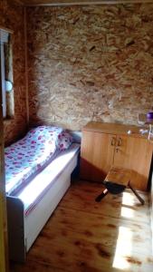 a bedroom with a bed and a wooden wall at Kuća Dragović Apartman in Kolašin