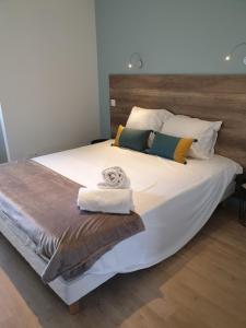 een slaapkamer met een groot bed en handdoeken bij Appartement Lac in Sévrier
