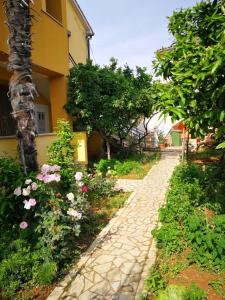a stone path in front of a house with flowers at Apartment Dalmatini in Vabriga