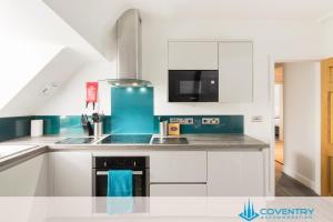 a kitchen with white cabinets and blue appliances at 2 Bedroom Apartment, NEC, HS2, BHX, JLR - Devereux House, Hosted By Coventry Accommodation in Coleshill