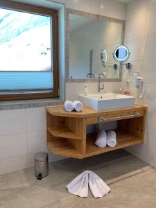 a bathroom with a sink and a mirror at Pension Alpenperle in Holzgau
