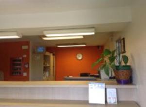 an office lobby with a counter and a clock at America's Best Inn - Macon in Macon