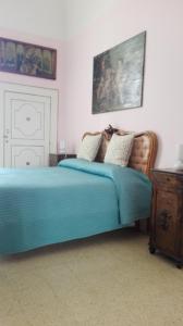 1 dormitorio con cama azul y tocador de madera en Villa Longo de Bellis, en Bari