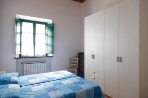 a bedroom with a blue and white bed and a window at Appartamento Napoleone by HelloElba in Portoferraio