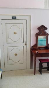 eine weiße Tür mit einem Schreibtisch und einer Uhr in der Unterkunft Villa Longo de Bellis in Bari