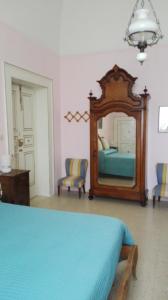 - une chambre avec un lit et un grand miroir dans l'établissement Villa Longo de Bellis, à Bari