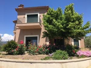 a house with flowers in front of it at Olive Tree Cottage 2 in Nea Peramos