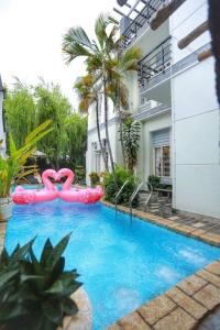 a swimming pool with two pink flamingos in a building at Sea Villa - 22 Bà Triệu in Vung Tau
