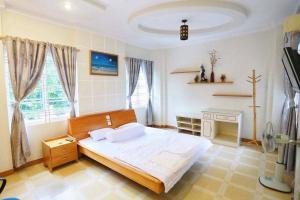 a bedroom with a large bed and a window at Sea Villa - 22 Bà Triệu in Vung Tau +4 photos