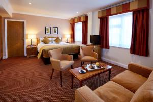 um quarto de hotel com uma cama e um sofá em The Bull em Gerrards Cross