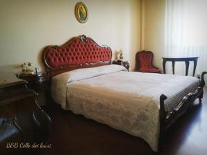 1 dormitorio con 1 cama grande y cabecero rojo en Colle dei lauri, en Loreto