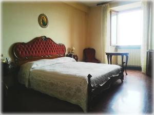 a bedroom with a bed with a red headboard and a window at Colle dei lauri in Loreto
