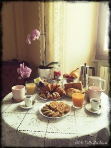 una mesa cubierta con platos de bollería y tazas de café en Colle dei lauri, en Loreto