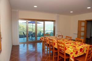 a dining room with a long table and chairs at Merck Villa Gerês in Rio Caldo