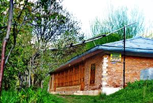 a small brick house with a blue roof at Spring Family Guest House in Tersak