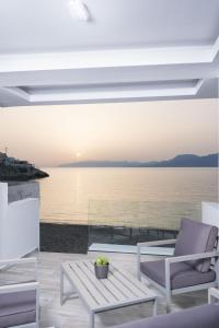 a view of the ocean from a house with chairs and a table at Thalassoresort DOWNSTAIRS in Matala +5 photos