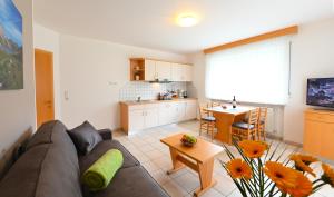salon z kanapą i stołem oraz kuchnia w obiekcie Residence Obstgarten w mieście Coldrano