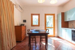 Una cocina con una mesa y sillas en una habitación. en Campagna De Mercedes, en Alghero