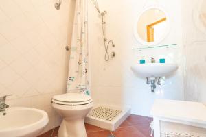 Un baño blanco con inodoro y lavabo. en Campagna De Mercedes, en Alghero
