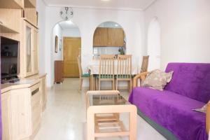 sala de estar con sofá púrpura y mesa en Apartamento LaLoma 72 №6, en Torrevieja