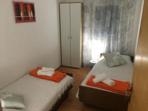 1 Schlafzimmer mit 2 Betten mit orangefarbenen und weißen Handtüchern in der Unterkunft Apartment Milin in Olib