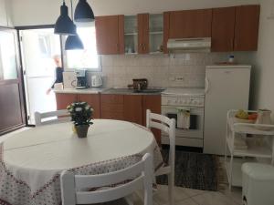 eine Küche mit einem weißen Tisch und einem weißen Kühlschrank in der Unterkunft Apartment Milin in Olib