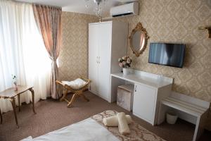 a bedroom with a bed and a tv on the wall at Golden House in Varna City