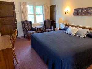 1 dormitorio con 1 cama azul y 2 sillas en The Holiday House, en Scarborough