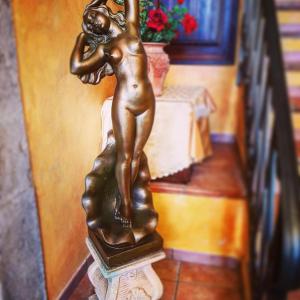 una estatua de bronce de una chica parada en un pedestal en L'Antica Dimora, en Macchiagodena
