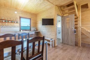 a dining room and kitchen in a log cabin at Domek Werbena in Ustka