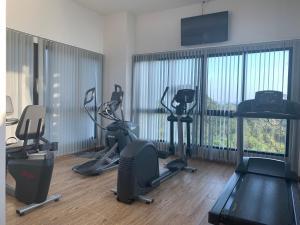 a gym with several treadmills and exercise bikes in a room at De Amber Pattaya by ME in Bang Sare